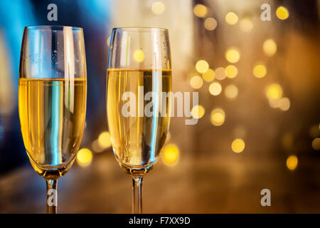 Image of two champagne glasses with blur lights in background Stock Photo