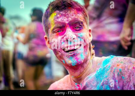 A young man covered in colored powder smiles during the Holi Festival of Colors at the Sri Sri Radha Krishna Temple March 29, 2014 in Spanish Fork, Utah. The festival follows the Indian tradition of Holi and attracts over 80,000 people. Stock Photo