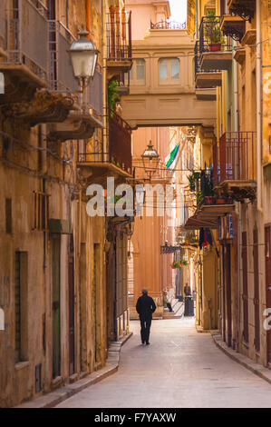 Sicily street, view in summer of a man walking along the Via Mario Rapisardi in the historic centre of Marsala, Sicily. Stock Photo