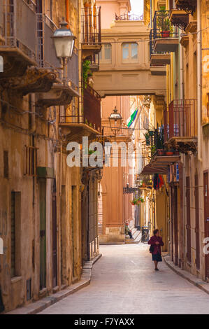 Marsala Sicily, view in summer of a senior woman walking alone in the Via Mario Rapisardi in the historic centre of Marsala, Sicily. Stock Photo