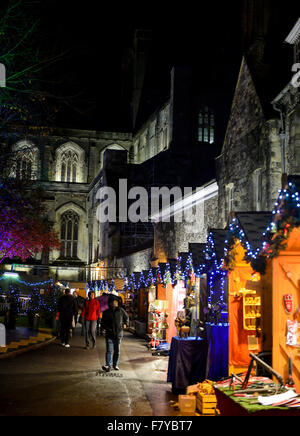 Winchester Christmas Market, Hampshire UK. Stalls of the annual Christmas market light up the grounds of Winchester Cathedral: 2 Stock Photo