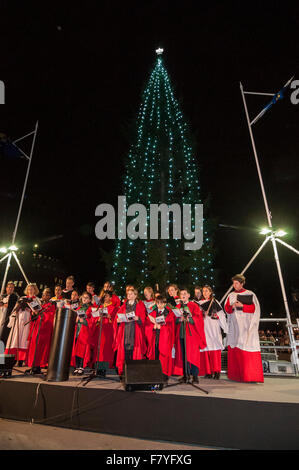 London, UK.  3 December 2015.  The choir of St. Martin in the Fields sing carols on stage during the annual lighting of the Christmas Tree lights ceremony in Trafalgar Square.  The tree is donated by the City of Oslo to the people of London each year as a token of gratitude for Britain’s support during the Second World War. Credit:  Stephen Chung / Alamy Live News Stock Photo