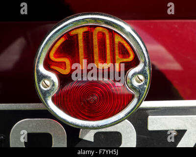 Vintage stop tail light sign on maroon classic car Stock Photo