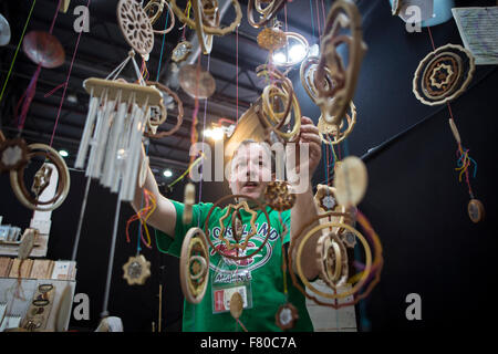 Buenos Aires, Argentina. 3rd Dec, 2015. An attendee watches mobile mandalas made of wood shown during the International Handcraft Fair in the exhibition center La Rural in the city of Buenos Aires, capital of Argentina, on Dec. 3, 2015. Artisans of all the country and Latin America present their products in the fair that includes metal, glass, and wood crafts, sculptures, jewelry, clothing, ceramic, decorations, toys and games, furniture, musical instruments, daily life articles, accesories and craft gastronomic products. © Martin Zabala/Xinhua/Alamy Live News Stock Photo