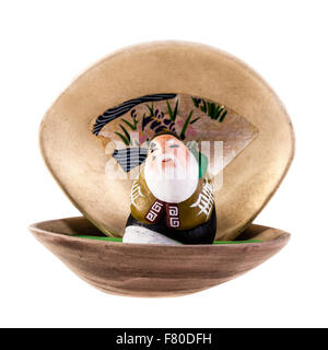 a chinese elder sage figurine in a seashell isolated over a white background Stock Photo