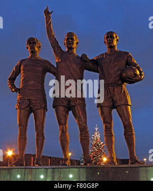 United Trinity/Holy Trinity statue of Manchester United trio of George Best, Denis Law, and Bobby Charlton at dusk Stock Photo