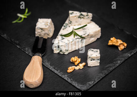 Slices of danish blue cheese on black slate Stock Photo