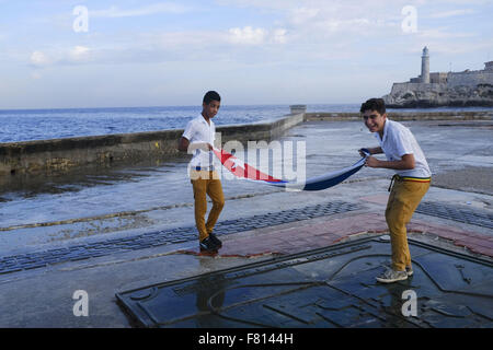 Havana, Cuba. 28th Oct, 2015. School children throw flowers into the ocean along the Malecon in honour of rebel hero Camilo Cienfuegos October 28, 2015 in Havana Cuba. Cienfuegos was a commander of Fidel Castro's rebel army. He died less than a year after their victory when his plane disappeared over the ocean on October 28, 1959. The plane and his body were never found. Cubans annuals throw flowers into the sea every October 28 to honour his passing. Photo Andre Forget © Andre Forget/ZUMA Wire/Alamy Live News Stock Photo