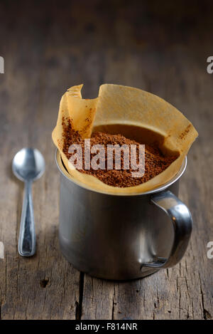 Coffee in a paper holder and cup on old wooden table Stock Photo