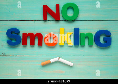 Broken cigarette and plastic letters spelling no smoking Stock Photo