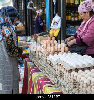 BISHKEK, KYRGYZSTAN - SEPTEMBER 27, 2015 : Woman selling eggs in local market. Stock Photo