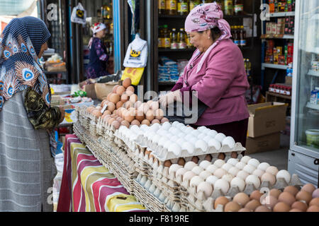 BISHKEK, KYRGYZSTAN - SEPTEMBER 27, 2015 : Woman selling eggs in local market. Stock Photo