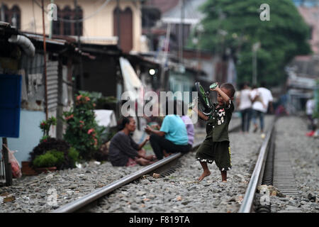 Medan, North Sumatra, Indonesia. 4th December, 2015. An Indonesian child standing on railroad tracks as they live in a slum, in Medan, North Sumatra, Indonesia, on December 4, 2015. The Indonesian government attempted to push them out of poverty by the poor population reached 28.59 million people, or 11 , 22 percent. Increased 860,000 people compared to September 2014 report, namely 27.73 million or 10.96 percent. According to the latest report of Indonesian Central Statistics Agency (BPS). Credit:  Ivan Damanik/Alamy Live News Stock Photo