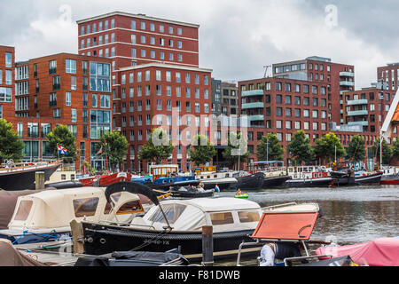 Small port with boats and typical red houses in Amsterdam Stock Photo