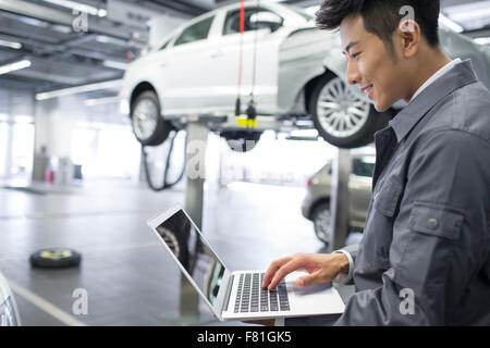 Auto mechanic using laptop Stock Photo