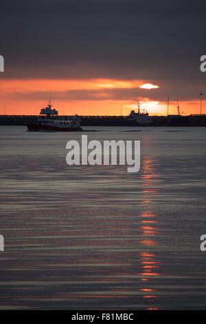 The midnight summer sun sets on the Summer Solstice over the harbor in Reykjavik, Iceland Stock Photo