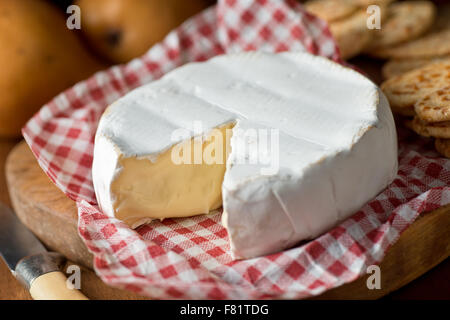 Delicious creamy wheel of brie cheese with crackers and pears. Stock Photo