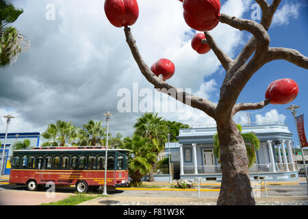 Trolley and sculpture (by the artist Ming Fay) at the center of the town of Yauco, Puerto Rico. USA territory. Caribbean Island. Stock Photo