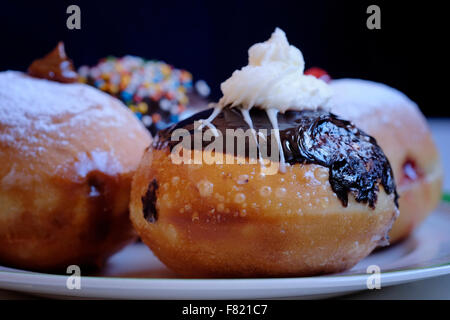 Elegantly traditional Sufganiyot deep fried round doughnut eaten during the Jewish holiday of Hanukkah, the festival of lights Stock Photo