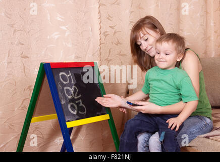 Mother teaches child to emergency phone numbers Stock Photo