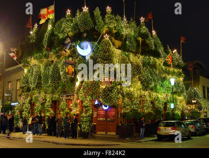London, UK. 4th December 2015. The Churchill Arms Pub has been covered in Christmas Trees in Kensington, London and is probably the pub decorated with the most Christmas Trees in the world. While most buildings content themselves with masses of lights, this pub goes the extra mile hiding beneath a veritable forest. Credit:  Paul Brown/Alamy Live News Stock Photo