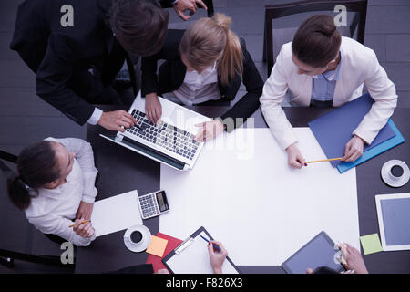 Business workplace with people, cup of coffee, digital tablet, smartphone, papers and various office objects on table Stock Photo