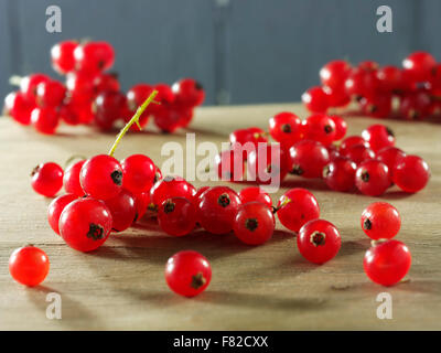 bunch of fresh redcurrants on a wooden table in a kitchen setting Stock Photo