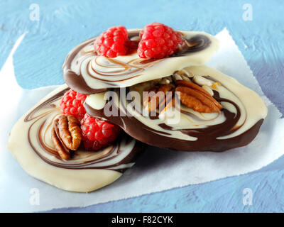 Melted milk and white chocolate swirls recipe with fruit and nuts Stock Photo