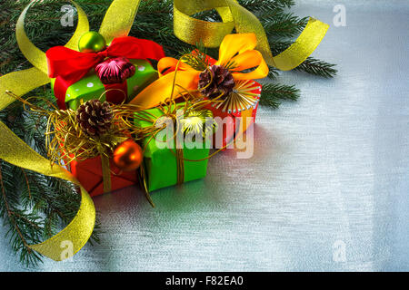 Christmas decoration with fir branches, gift boxes, bows, balls, ornament on silver sparkles background, selective focus Stock Photo