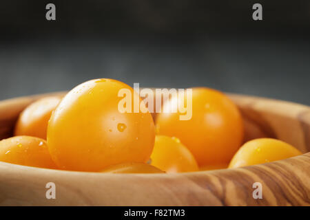 yellow cherry tomatoes in wood bowl Stock Photo