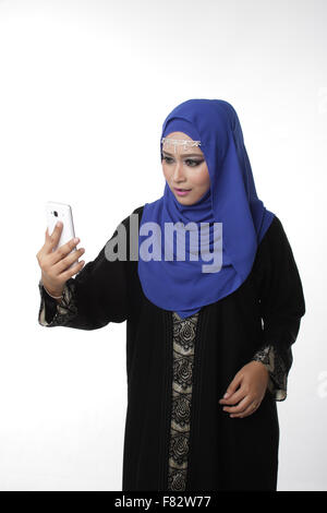 Malaysian malay woman using a cell phone or smartphone with different expression isolated in white