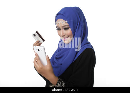 Malaysian malay asian woman using a smart phone or cell phone to shopping online