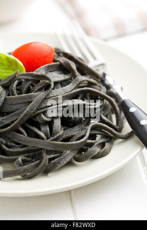 cooked black noodles with squid sepia ink on plate