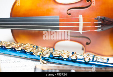 Blue flute detail with out of focus wooden violin and score Stock Photo