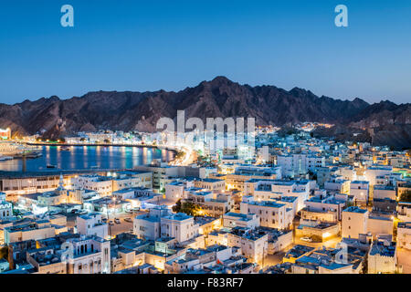 Dusk view of the district of Mutrah and surrounding mountains in Muscat, the capital of the Sultanate of Oman. Stock Photo