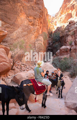 Tourists riding on donkeys in Petra, Jordan Stock Photo