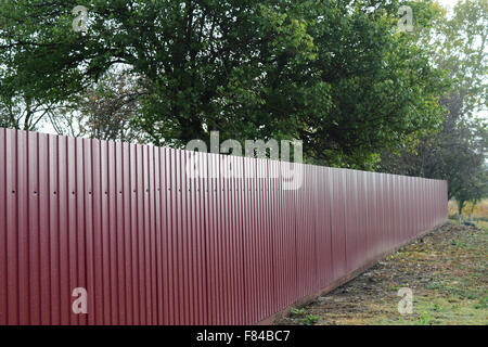 Diagonal pattern of metal profile. Fences from the galvanized iron painted by a polymeric covering. Stock Photo