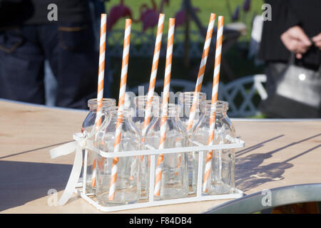 Old Milk bottles in a rack with straws Stock Photo
