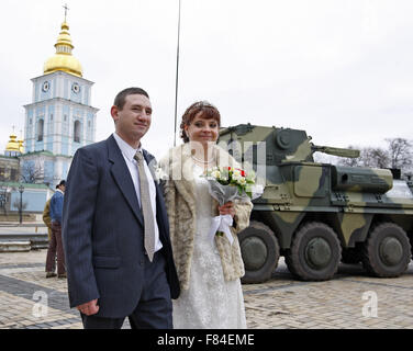Kiev, Ukraine. 05th Dec, 2015. Ukrainian newlywed walks near the BTR-4, during the opening of the military exhibition 'Weapons of victory' during the Day of the Armed Forces of Ukraine at St. Michael's Square. The exhibition presents Ukrainian armored personnel carriers BTR-3 and BTR-4, and the new armored car Dozor-B, which will soon be sent to the East of Ukraine. © Vasyl Shevchenko/Pacific/Alamy Live News Stock Photo