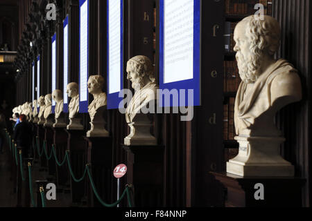 The statues of ancient scholars display inside of the  Long Room of the Old Library in Trinity College in Dublin, Ireland Stock Photo