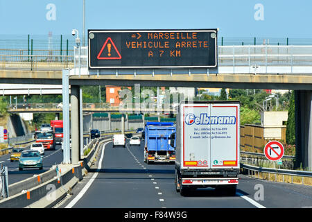 French autoroute motorway road rear and back view of lorry traffic below gantry mounted electronic information sign in Provence France Stock Photo