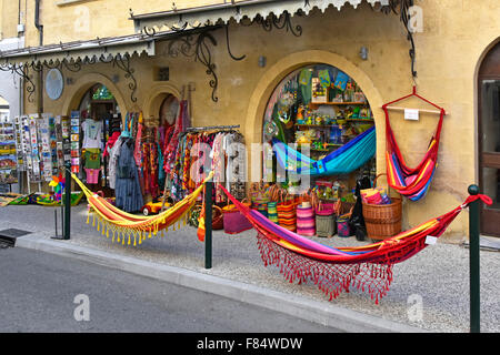 Lourmarin village street shop front pavement display of touristy summer merchandise including hammocks in Luberon, Provence Vaucluse Stock Photo