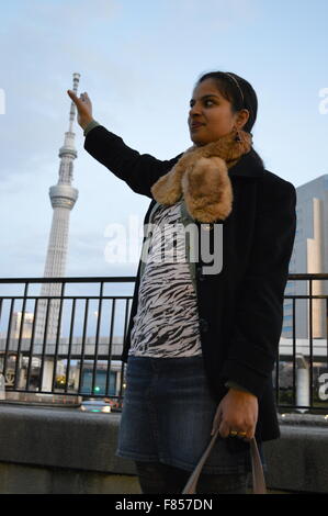 Indian Couple posing near sumida river tokyo, with illuminating Tokyo sky tree in background Stock Photo