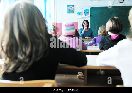happy young teacher woman at elementrary school teaching and giving leassons to group of young smart children Stock Photo