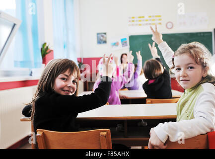 happy young teacher woman at elementrary school teaching and giving leassons to group of young smart children Stock Photo