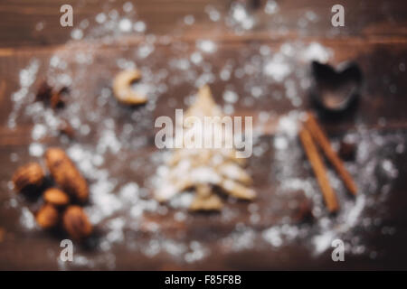 Out of focus Christmas tree and moon with flour on wooden table Stock Photo