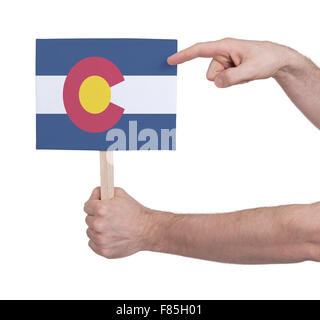 Hand holding small card, isolated on white - Flag of Colorado Stock Photo