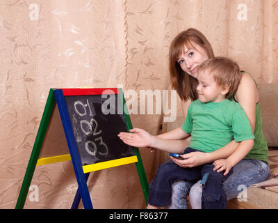 Mother teaches child to emergency phone numbers Stock Photo