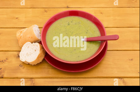 Full bowl of pea and ham soup with slices of baguette beside Stock Photo