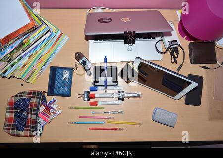 A messy study table of student with electronic devices and study stuffs ...